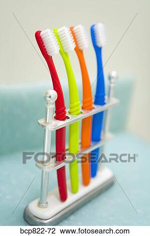 Stock Image - Assorted colorful toothbrushes in stand. Fotosearch