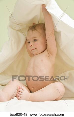 Baby lifting blanket in bed View Large Photo Image Stock Photo - Baby lifting blanket in bed. Fotosearch