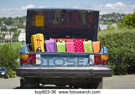 Car trunk loaded with colorful suitcases View Large Photo Image Stock Photograph - Car trunk loaded with colorful suitcases. Fotosearch