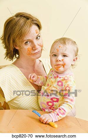 Frustrated mother feeding messy baby View Large Photo Image Stock Image - Frustrated mother feeding messy baby. Fotosearch
