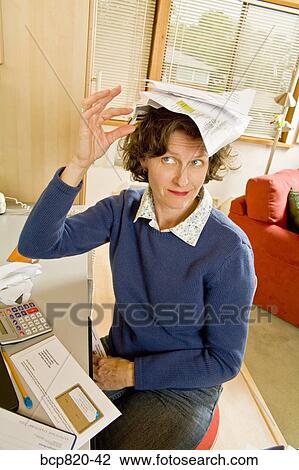 Frustrated woman balancing bills on head in home office View Large Photo Image Stock Image - Frustrated woman balancing bills on head in home office. Fotosearch