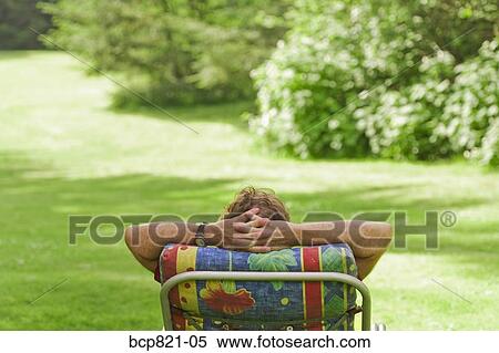 Man relaxing in lounge chair View Large Photo Image Stock Photography - Man relaxing in lounge chair. Fotosearch