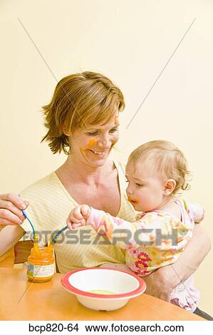 Mother feeding messy baby View Large Photo Image Picture - Mother feeding messy baby. Fotosearch