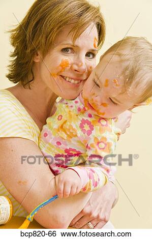 Mother feeding messy baby View Large Photo Image Stock Photograph - Mother feeding messy baby. Fotosearch