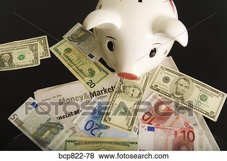 Stock Photo - Piggy bank, cash and financial section of newspaper. Fotosearch