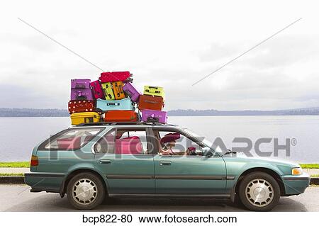 Woman and dog driving car stacked with colorful suitcases View Large Photo Image Stock Image - Woman and dog driving car stacked with colorful suitcases. Fotosearch