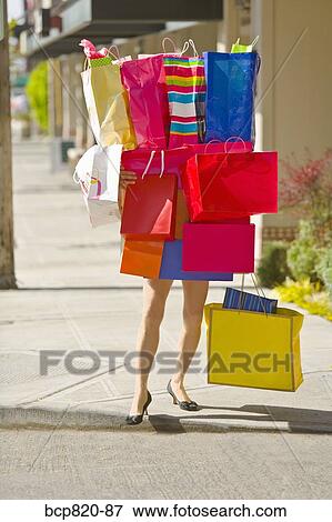 Woman balancing assorted shopping bags View Large Photo Image Stock Photo - Woman balancing assorted shopping bags. Fotosearch