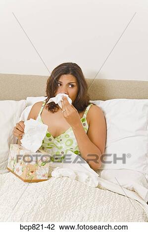 Woman blowing nose in bed View Large Photo Image Stock Image - Woman blowing nose in bed. Fotosearch