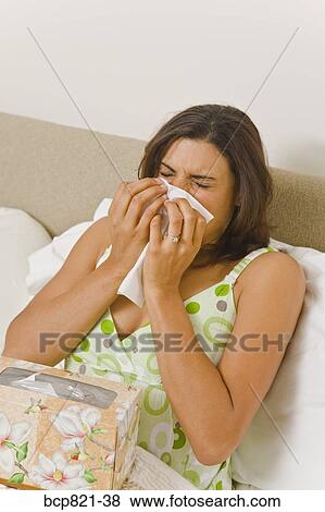 Woman blowing nose in bed View Large Photo Image Stock Photo - Woman blowing nose in bed. Fotosearch