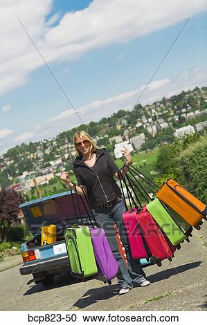 Woman carrying many colorful suitcases View Large Photo Image Stock Image - Woman carrying many colorful suitcases. Fotosearch