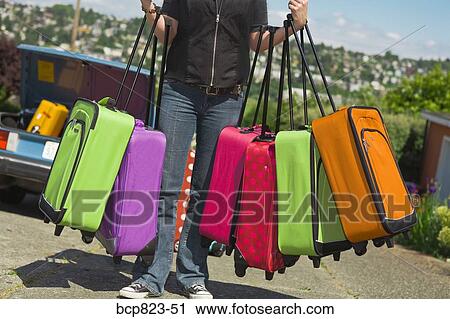 Woman carrying many colorful suitcases View Large Photo Image Stock Image - Woman carrying many colorful suitcases. Fotosearch