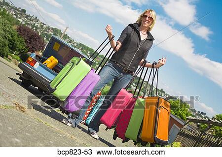 Woman carrying many colorful suitcases View Large Photo Image Stock Image - Woman carrying many colorful suitcases. Fotosearch