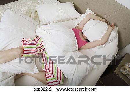 Woman covering head with pillow in bed View Large Photo Image Stock Image - Woman covering head with pillow in bed. Fotosearch