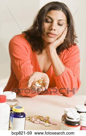 Woman holding handful of vitamins and supplements View Large Photo Image Stock Photo - Woman holding handful of vitamins and supplements. Fotosearch