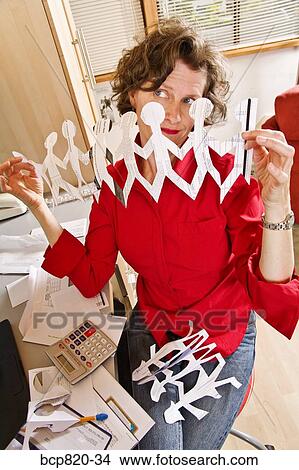 Woman holding row of paper dolls in home office View Large Photo Image Picture - Woman holding row of paper dolls in home office. Fotosearch