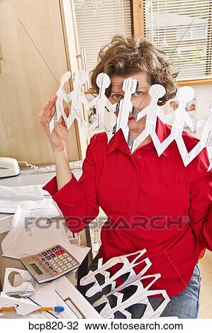 Woman holding row of paper dolls in home office View Large Photo Image Stock Image - Woman holding row of paper dolls in home office. Fotosearch