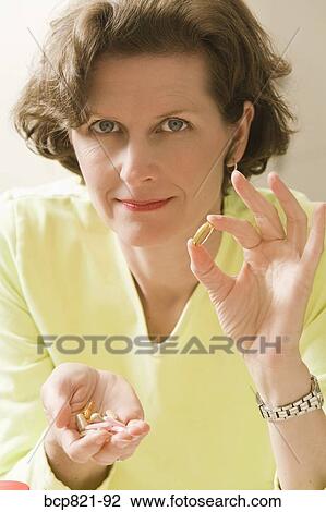 Woman holding vitamins and supplements View Large Photo Image Stock Image - Woman holding vitamins and supplements. Fotosearch