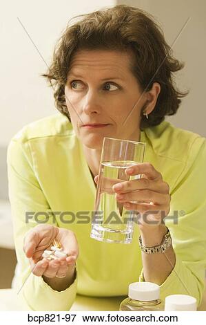 Woman holding vitamins and supplements View Large Photo Image Stock Photo - Woman holding vitamins and supplements. Fotosearch