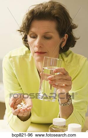 Woman holding vitamins and supplements View Large Photo Image Stock Photograph - Woman holding vitamins and supplements. Fotosearch