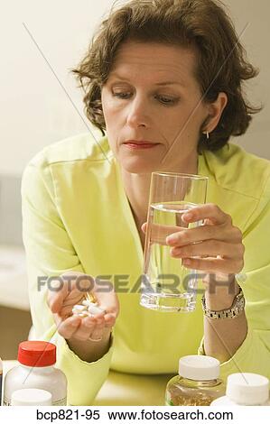 Woman holding vitamins and supplements View Large Photo Image Stock Photography - Woman holding vitamins and supplements. Fotosearch