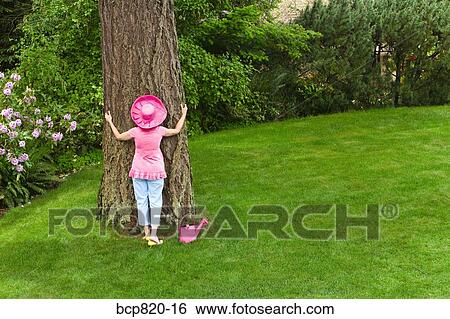 Woman in festive pink hat hugging tree View Large Photo Image Stock Photograph - Woman in festive pink hat hugging tree. Fotosearch
