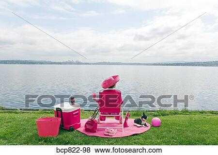 Stock Photo - Woman in pink and Boston Terrier dog picnicking by bay. Fotosearch