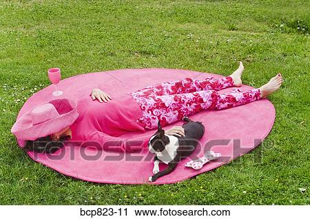 Woman in pink and dog relaxing outdoors on rug View Large Photo Image Stock Image - Woman in pink and dog relaxing outdoors on rug. Fotosearch