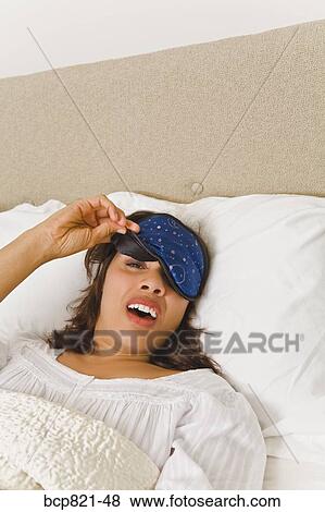 Woman lifting eye mask in bed View Large Photo Image Stock Photo - Woman lifting eye mask in bed. Fotosearch