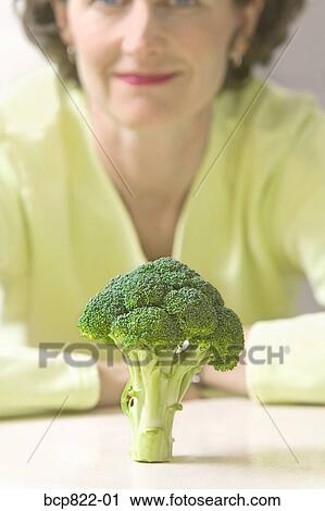 Woman looking at broccoli View Large Photo Image Stock Image - Woman looking at broccoli. Fotosearch