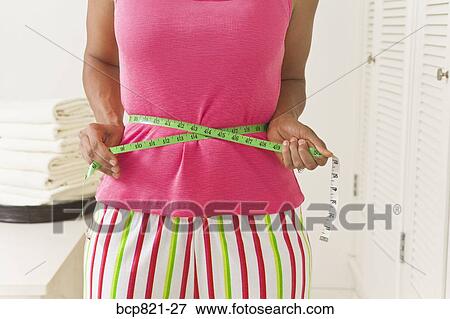 Woman measuring waist with measuring tape View Large Photo Image Stock Photo - Woman measuring waist with measuring tape. Fotosearch