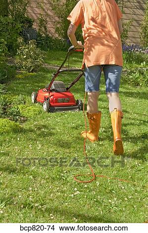 Woman mowing lawn with electric mower View Large Photo Image Picture - Woman mowing lawn with electric mower. Fotosearch