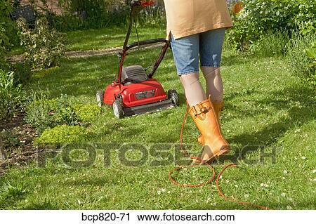 Woman mowing lawn with electric mower View Large Photo Image Stock Image - Woman mowing lawn with electric mower. Fotosearch