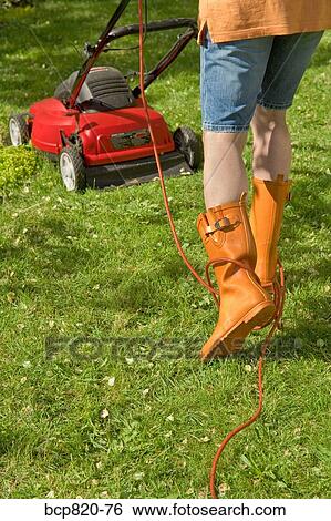 Woman mowing lawn with electric mower View Large Photo Image Stock Photograph - Woman mowing lawn with electric mower. Fotosearch