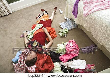 Woman on bedroom floor buried under clothing View Large Photo Image Picture - Woman on bedroom floor buried under clothing. Fotosearch
