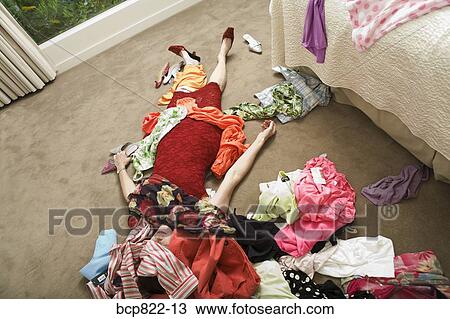 Woman on bedroom floor buried under clothing View Large Photo Image Stock Image - Woman on bedroom floor buried under clothing. Fotosearch