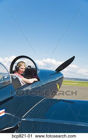 Woman pilot sitting in vintage airplane View Large Photo Image Stock Image - Woman pilot sitting in vintage airplane. Fotosearch