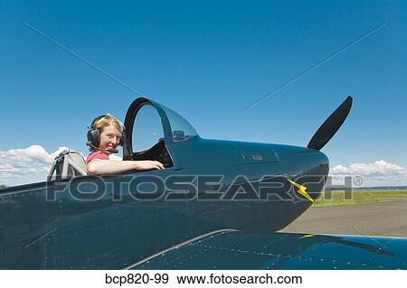 Woman pilot sitting in vintage airplane View Large Photo Image Stock Photo - Woman pilot sitting in vintage airplane. Fotosearch
