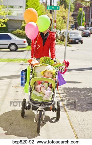 Woman pushing baby girl in stroller View Large Photo Image Stock Image - Woman pushing baby girl in stroller. Fotosearch