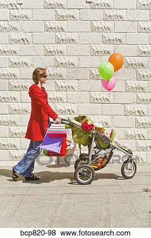 Woman pushing baby girl in stroller View Large Photo Image Stock Photo - Woman pushing baby girl in stroller. Fotosearch