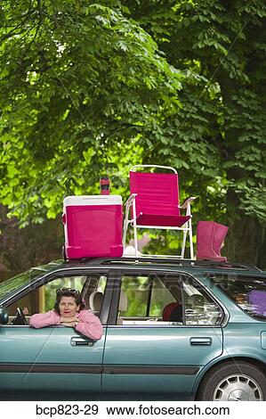 Woman sitting in car with picnic set on top View Large Photo Image Stock Photo - Woman sitting in car with picnic set on top. Fotosearch