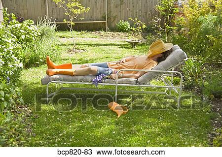 Woman sleeping on lounge chair in backyard garden View Large Photo Image Stock Image - Woman sleeping on lounge chair in backyard garden. Fotosearch