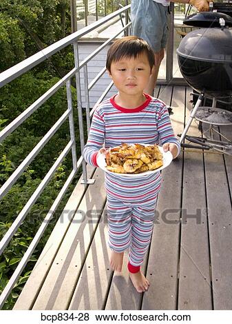 Boy carrying food on a plate View Large Photo Image Stock Photo - Boy carrying food on a plate. Fotosearch