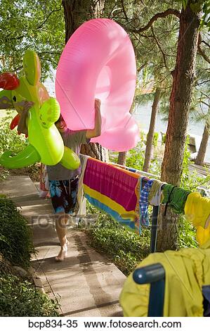 Boy carrying inflatable toys View Large Photo Image Stock Photography - Boy carrying inflatable toys. Fotosearch