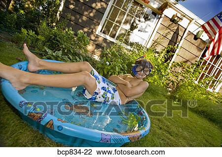 Boy wearing snorkel and lying in a wading pool View Large Photo Image Stock Image - Boy wearing snorkel and lying in a wading pool. Fotosearch