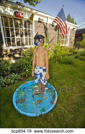 Boy wearing snorkel and standing in a wading pool View Large Photo Image Stock Photo - Boy wearing snorkel and standing in a wading pool. Fotosearch