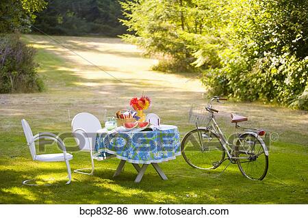 Breakfast table and a bicycle in a garden View Large Photo Image Stock Photograph - Breakfast table and a bicycle in a garden. Fotosearch