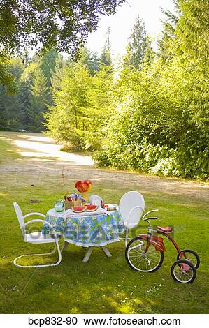 Breakfast table and a tricycle in a garden View Large Photo Image Stock Image - Breakfast table and a tricycle in a garden. Fotosearch