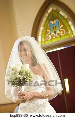 Bride holding a bouquet of flowers in a church, East Meredith, New York State, USA View Large Photo Image Stock Photography - Bride holding a bouquet of flowers in a church, East Meredith, New York State, USA. Fotosearch