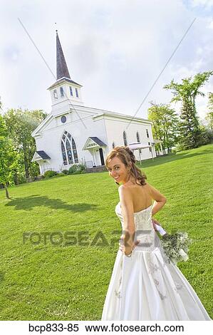 Stock Photography - Bride standing near a church, East Meredith, New York State, USA. Fotosearch