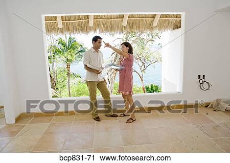 Stock Image - Couple holding document and discussing. Fotosearch